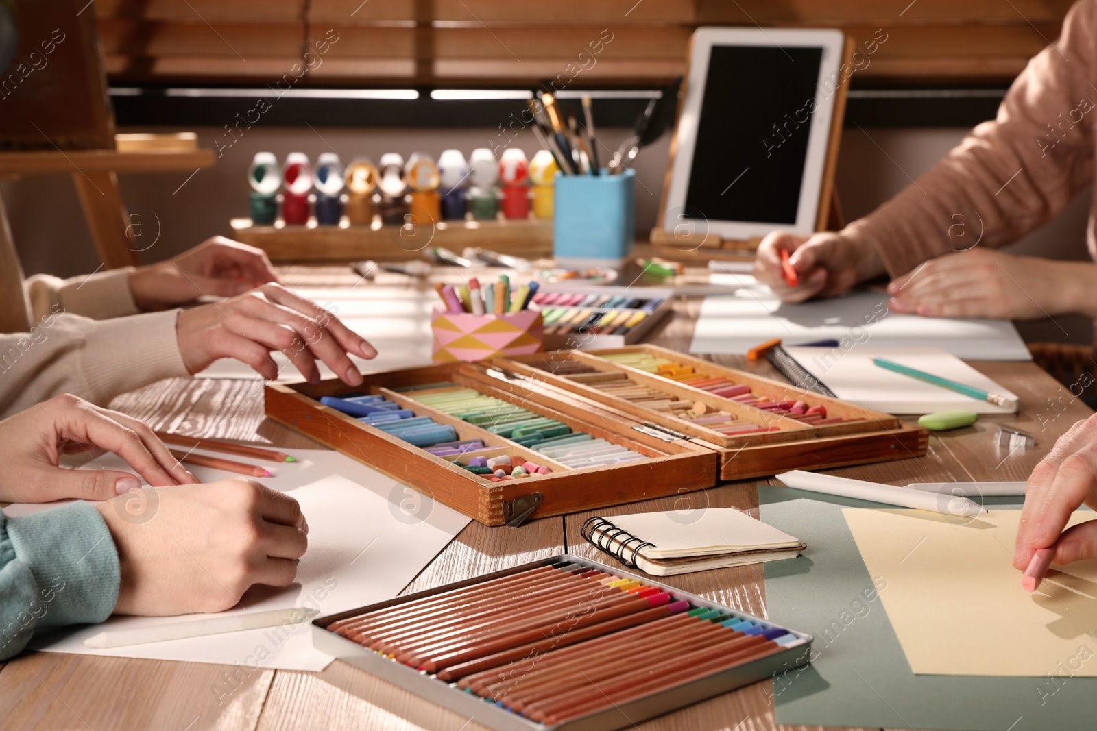 Photo of Artists drawing with soft pastels at table, closeup