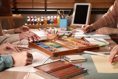 Photo of Artists drawing with soft pastels at table, closeup