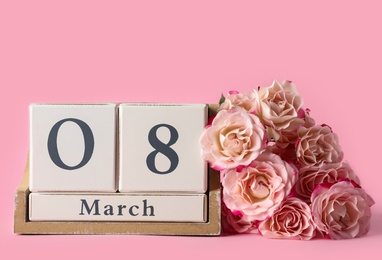 Photo of Wooden block calendar with date 8th of March and roses on pink background, space for text. International Women's Day