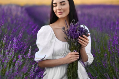 Photo of Beautiful young woman with bouquet in lavender field