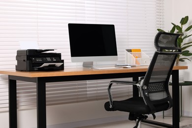 Photo of Stylish room interior with desk, modern printer and computer