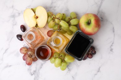 Photo of Different types of vinegar and ingredients on light marble table, flat lay