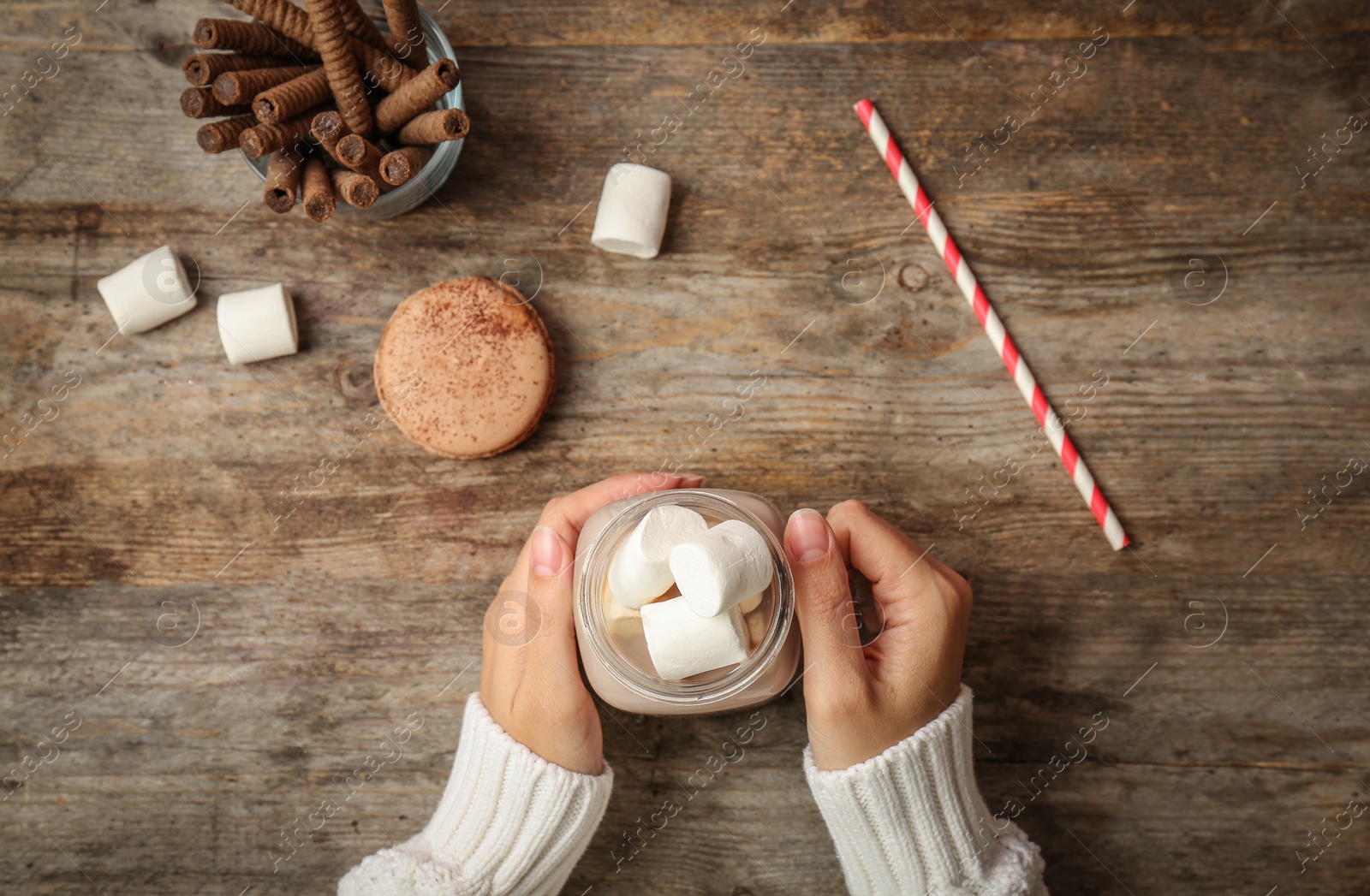 Photo of Woman with delicious hot cocoa drink at table, top view