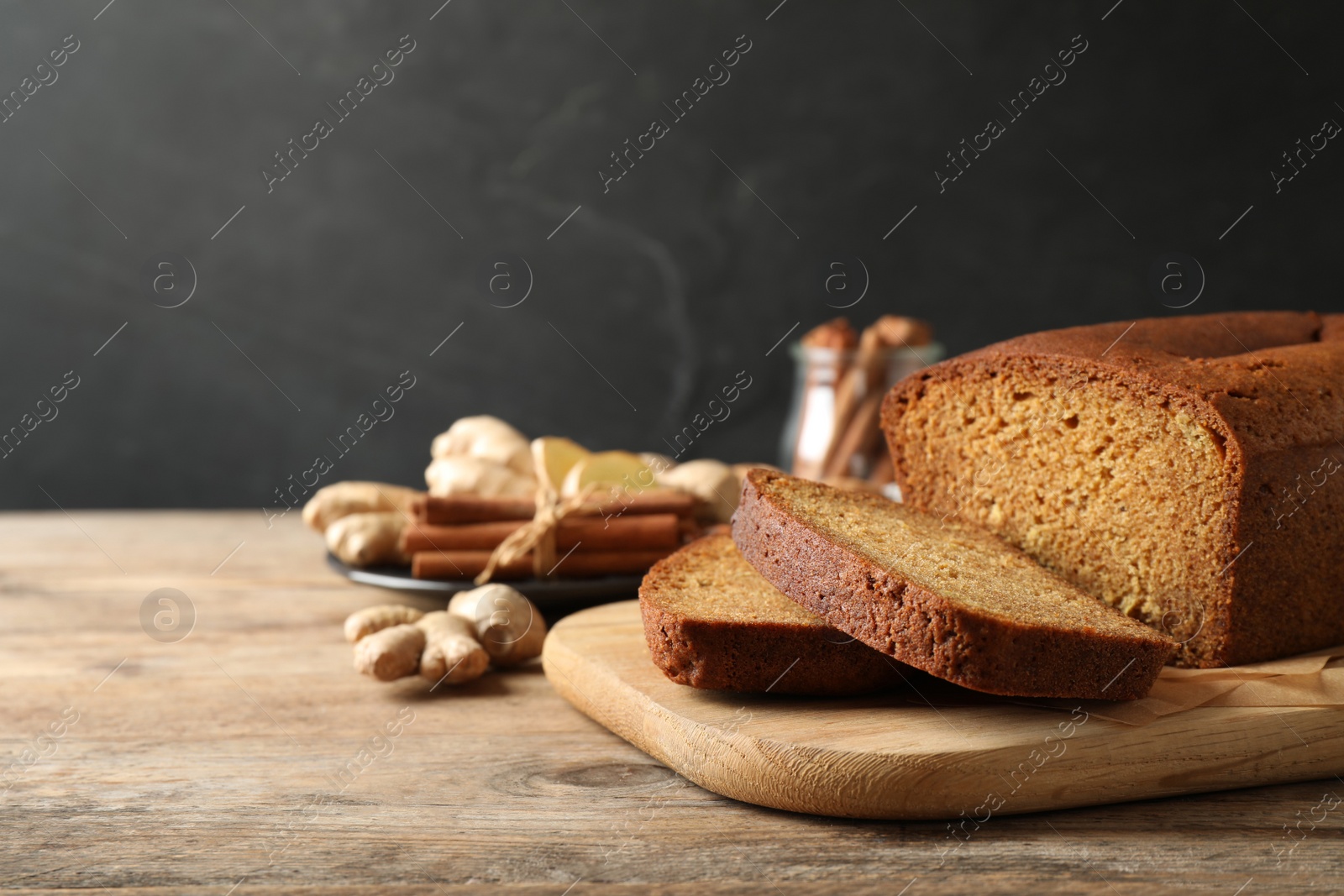 Photo of Fresh sliced gingerbread cake on wooden table, space for text