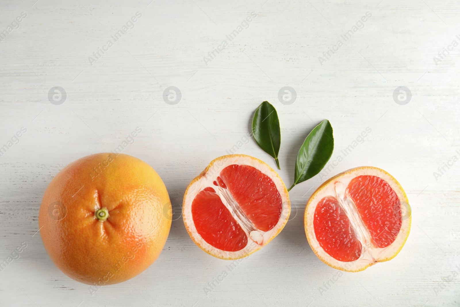 Photo of Fresh tasty grapefruits on wooden background, top view with space for text