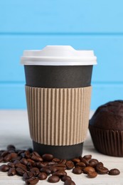 Photo of Paper cup with plastic lid and coffee beans on white table, closeup. Coffee to go