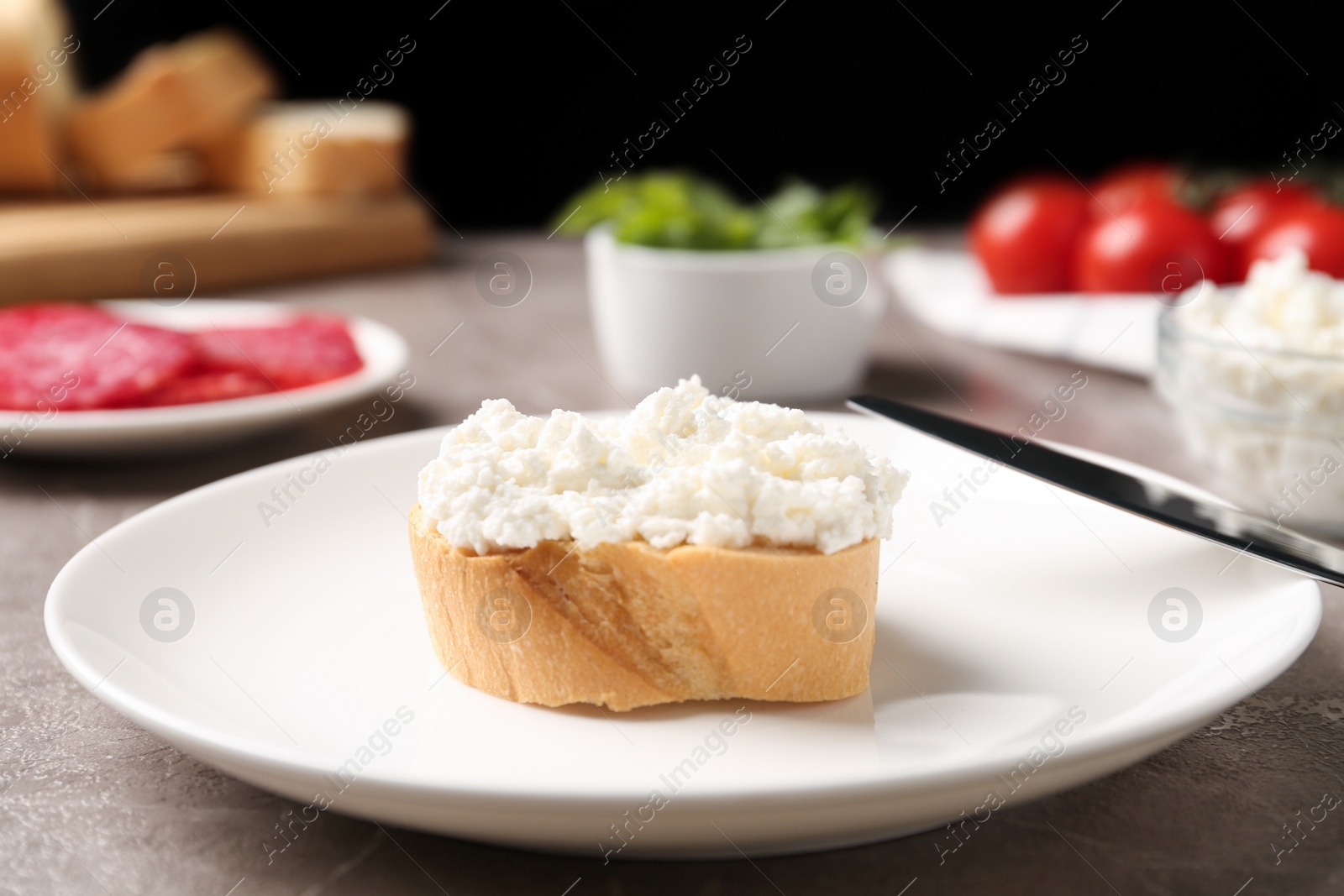 Photo of Delicious bruschetta with cheese and products on grey table
