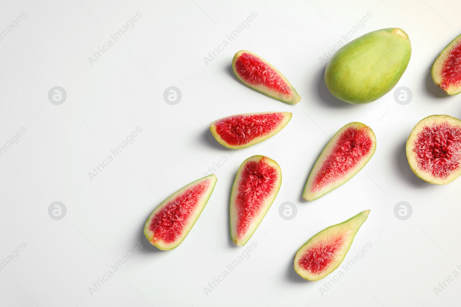 Photo of Flat lay composition with fresh ripe fig slices on white background. Space for text