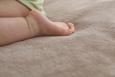 Photo of Baby sitting on bed at home, closeup. Space for text