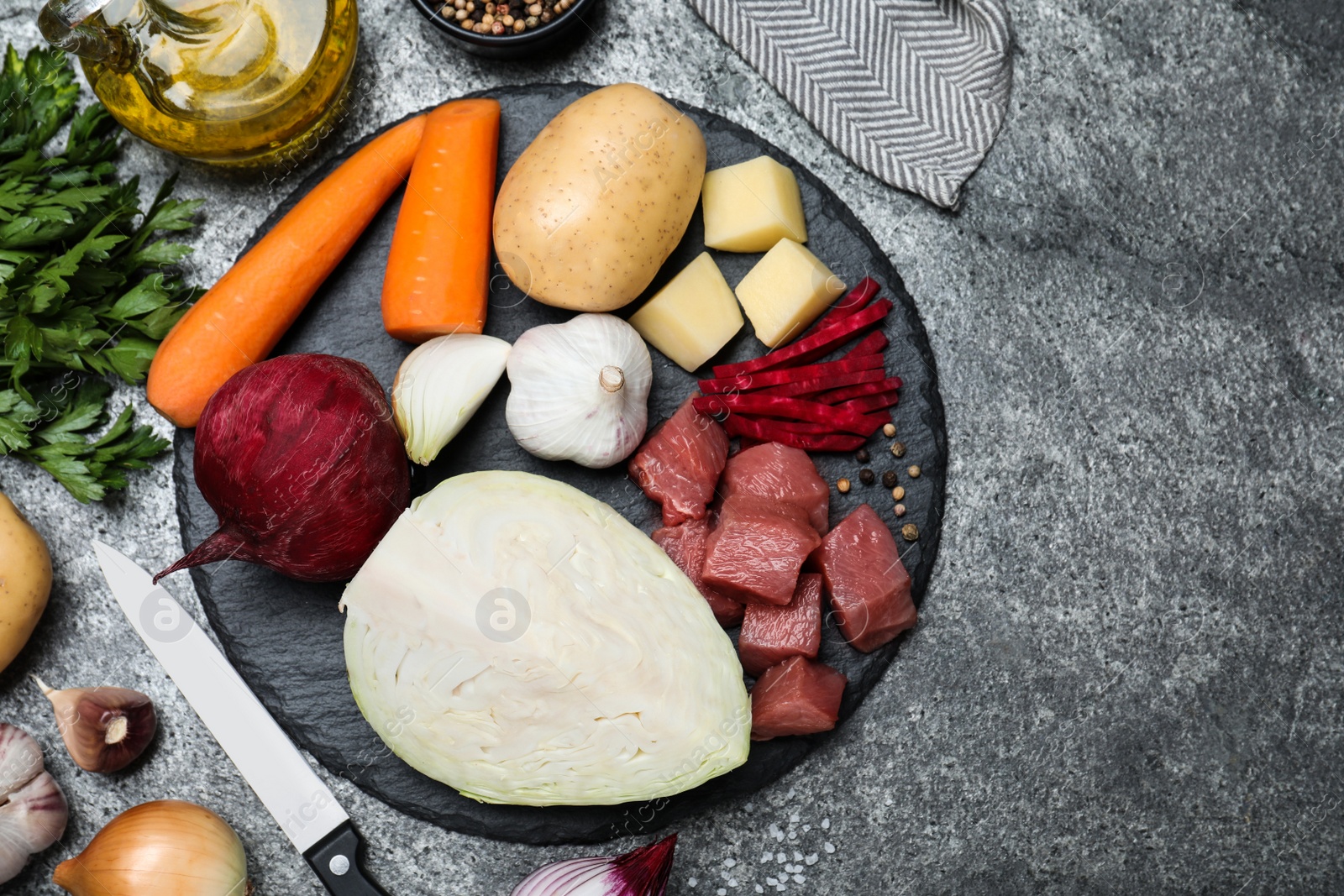 Photo of Ingredients for traditional borscht on grey table, flat lay