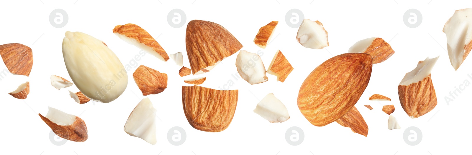 Image of Pieces of tasty almonds falling on white background. Banner design