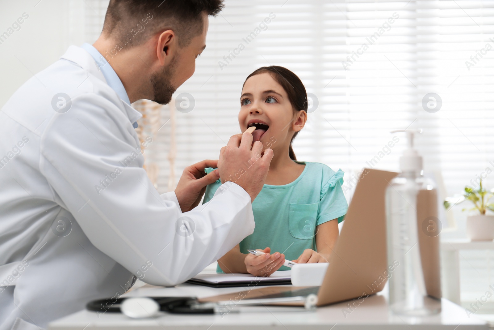 Photo of Pediatrician examining little girl in office at hospital