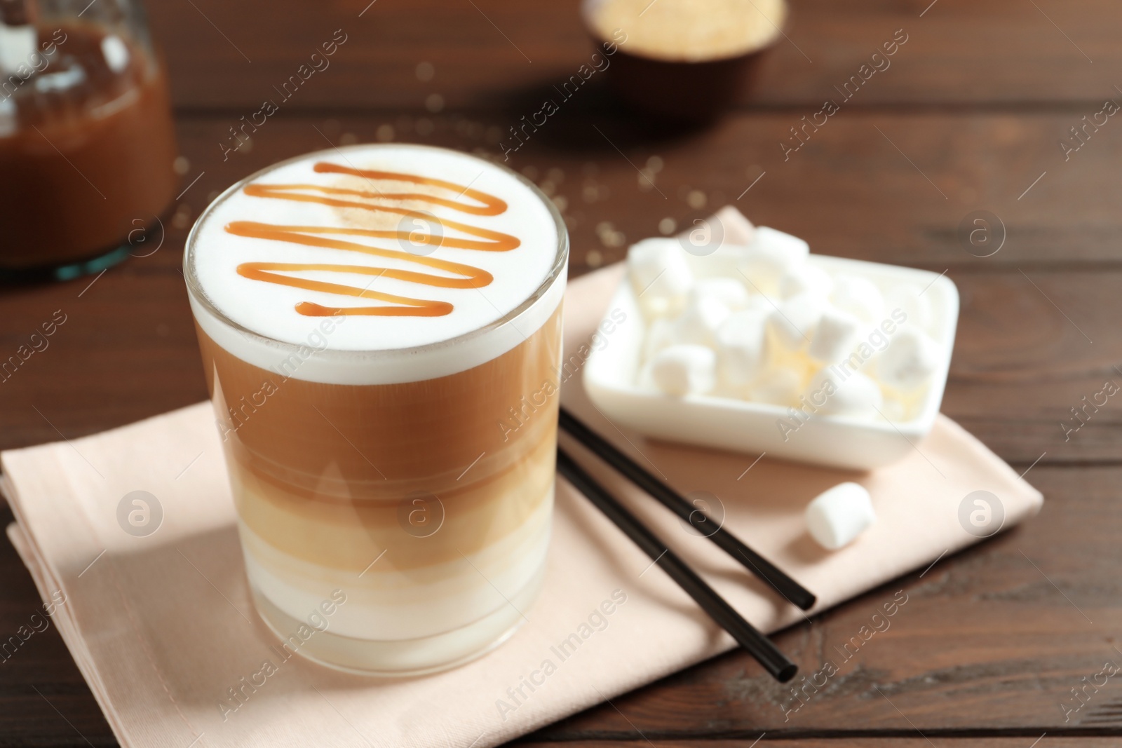 Photo of Glass with delicious caramel latte on table