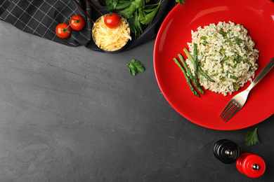 Photo of Delicious risotto with asparagus served on grey table, flat lay. Space for text