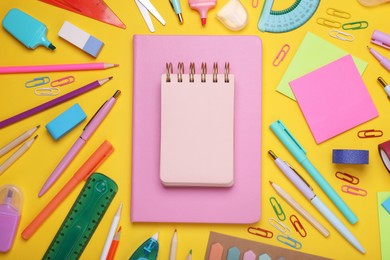 Flat lay composition with notebooks and other school stationery on yellow background, space for text. Back to school