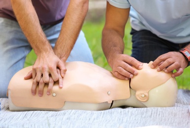 Photo of People having first aid class with mannequin outdoors