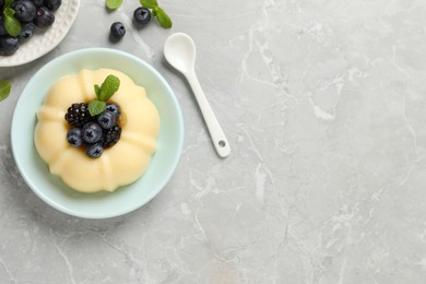 Delicious semolina pudding with berries on light grey table, flat lay. Space for text