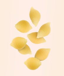 Image of Raw conchiglie pasta flying on beige background