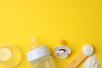 Photo of Flat lay composition with powdered infant formula on yellow background, space for text. Baby milk