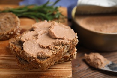 Photo of Fresh bread with delicious meat pate on wooden table, closeup