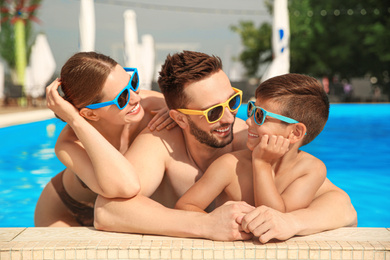 Happy family in swimming pool on sunny day