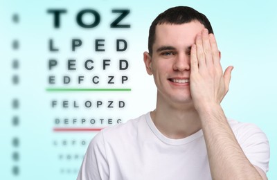 Vision test. Young man and eye chart on gradient background