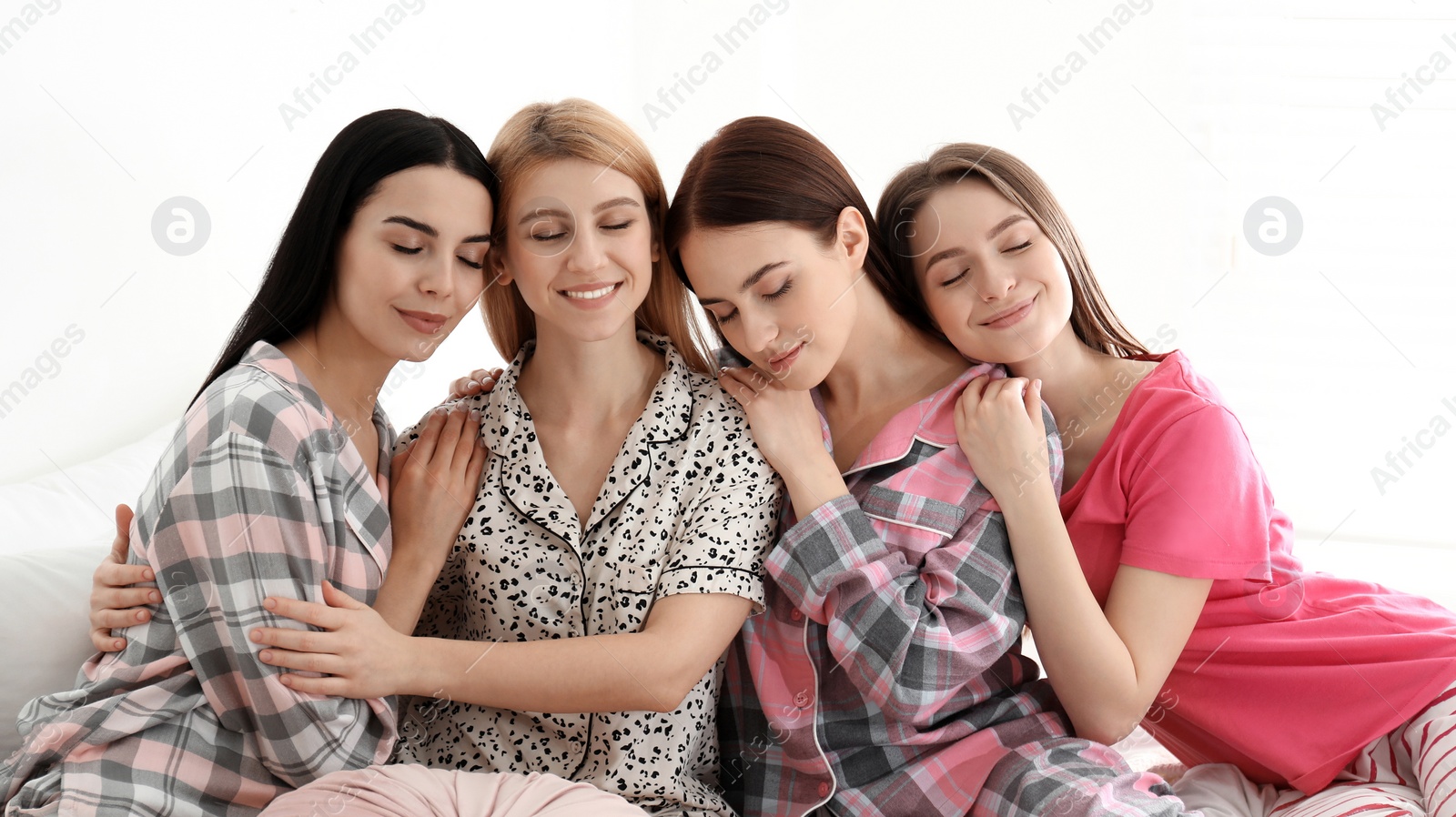 Photo of Beautiful young ladies on bed at pamper party. Women's Day