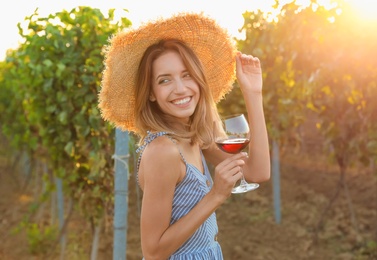 Photo of Young beautiful woman enjoying wine at vineyard