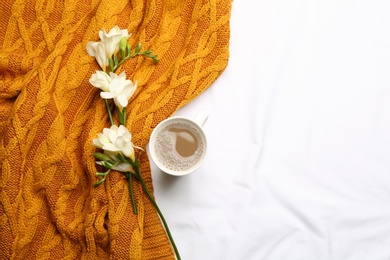 Photo of Flat lay composition with coffee and warm plaid on white bedsheet, space for text