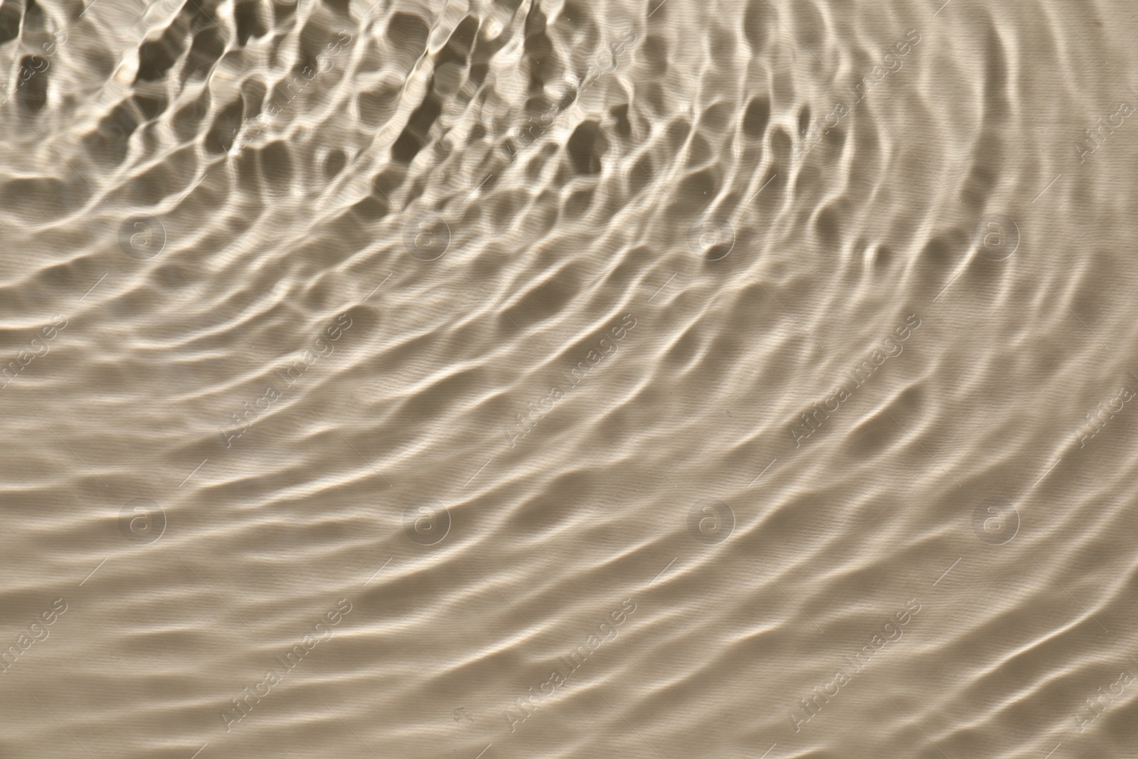 Photo of Rippled surface of clear water on beige background, top view