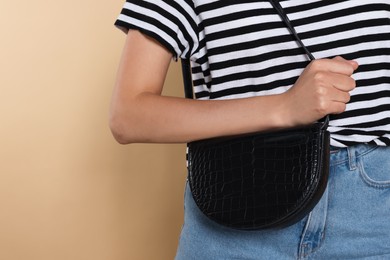 Photo of Woman with stylish bag on beige background, closeup