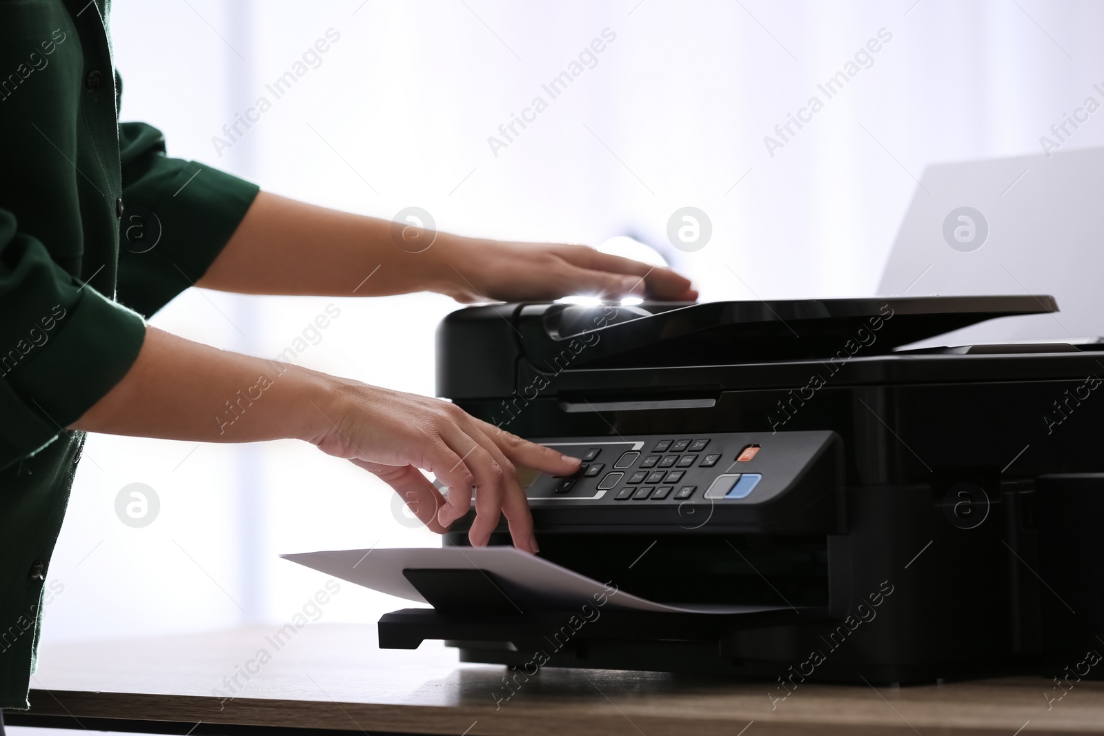 Photo of Employee using modern printer in office, closeup