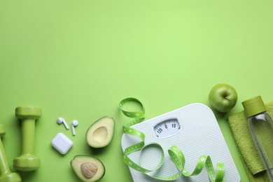 Photo of Flat lay composition with scales and measuring tape on green background, space for text