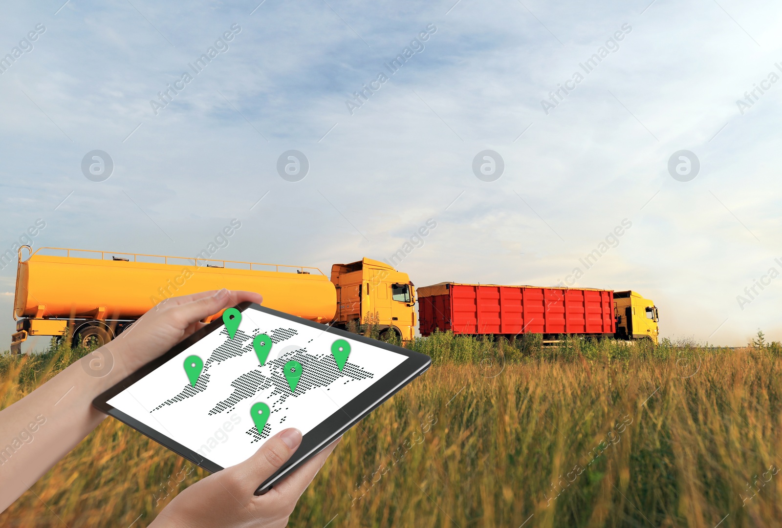 Image of Logistics concept. Woman using tablet with world map on screen against trucks
