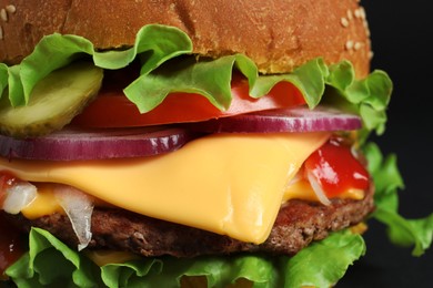 Delicious burger with beef patty and lettuce on dark background, closeup
