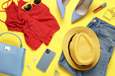 Flat lay composition with smartphone and stylish clothes on yellow background