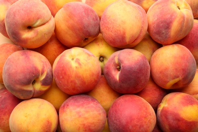 Photo of Fresh ripe peaches as background, top view