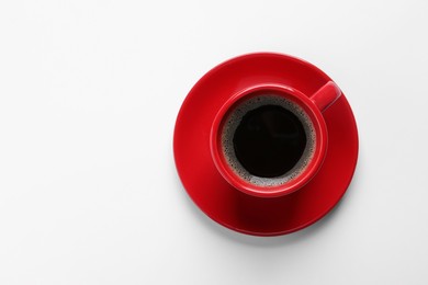 Photo of Red cup with aromatic coffee on white background, top view. Space for text