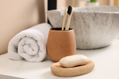 Photo of Different bath accessories and personal care products near sink on bathroom vanity, closeup