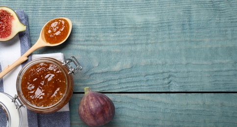 Flat lay composition with homemade delicious fig jam on blue wooden table. Space for text