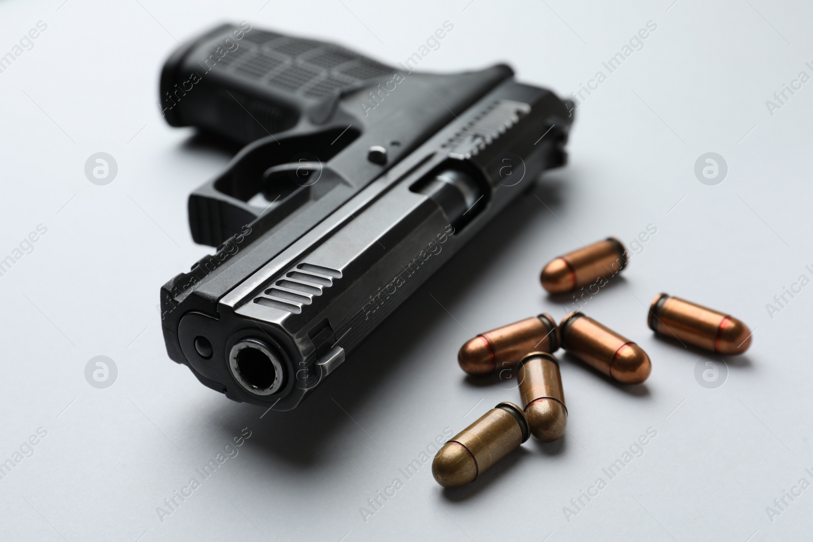 Photo of Semi-automatic pistol and bullets on light background, closeup