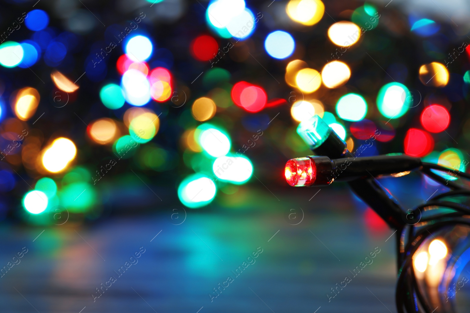 Photo of Glowing Christmas lights on dark background, closeup