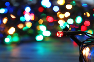 Glowing Christmas lights on dark background, closeup