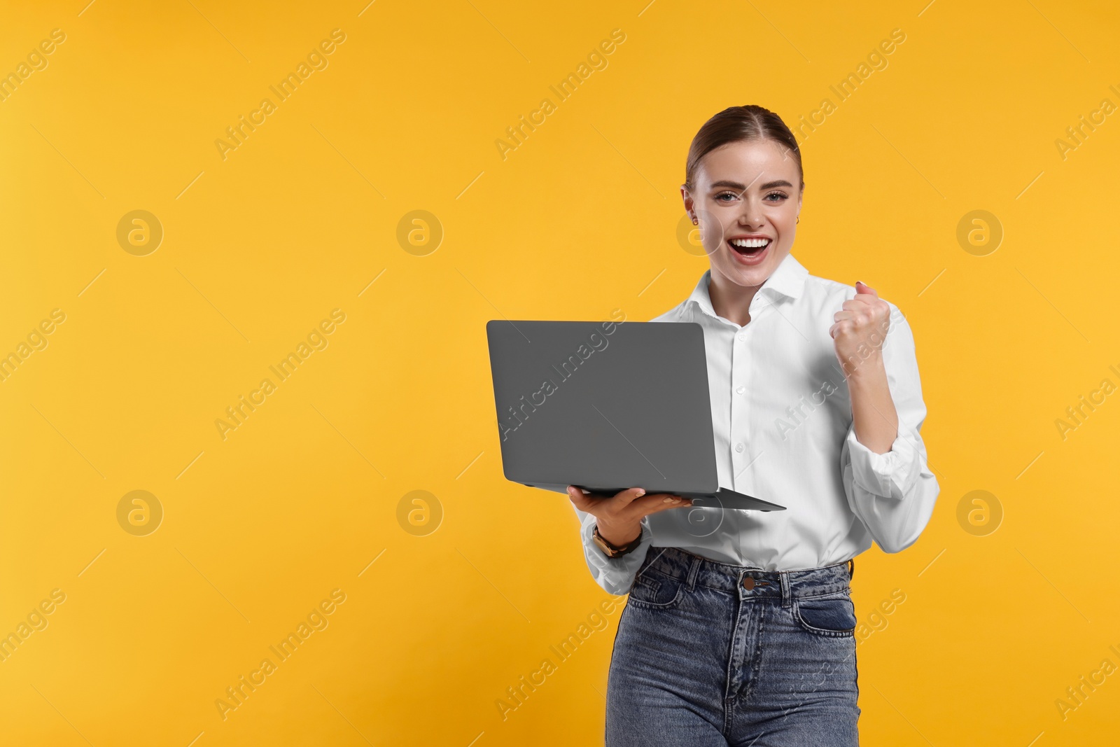 Photo of Happy woman with laptop on orange background. Space for text