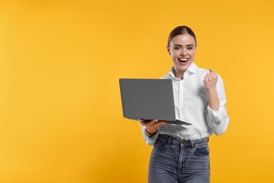 Photo of Happy woman with laptop on orange background. Space for text