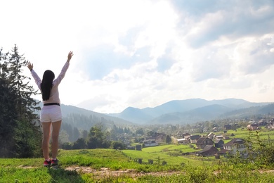 Young woman enjoying beautiful view of village in mountains