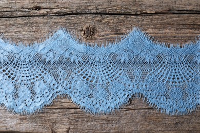 Photo of Beautiful lace on wooden table, top view