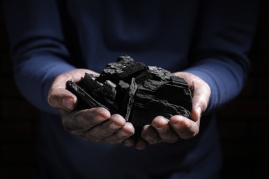 Man with handful of coal, closeup view