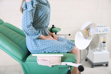 Photo of Gynecological checkup. Woman sitting on examination chair in hospital, closeup