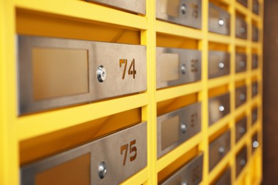 Many closed metal mailboxes with keyholes and numbers in post office, closeup